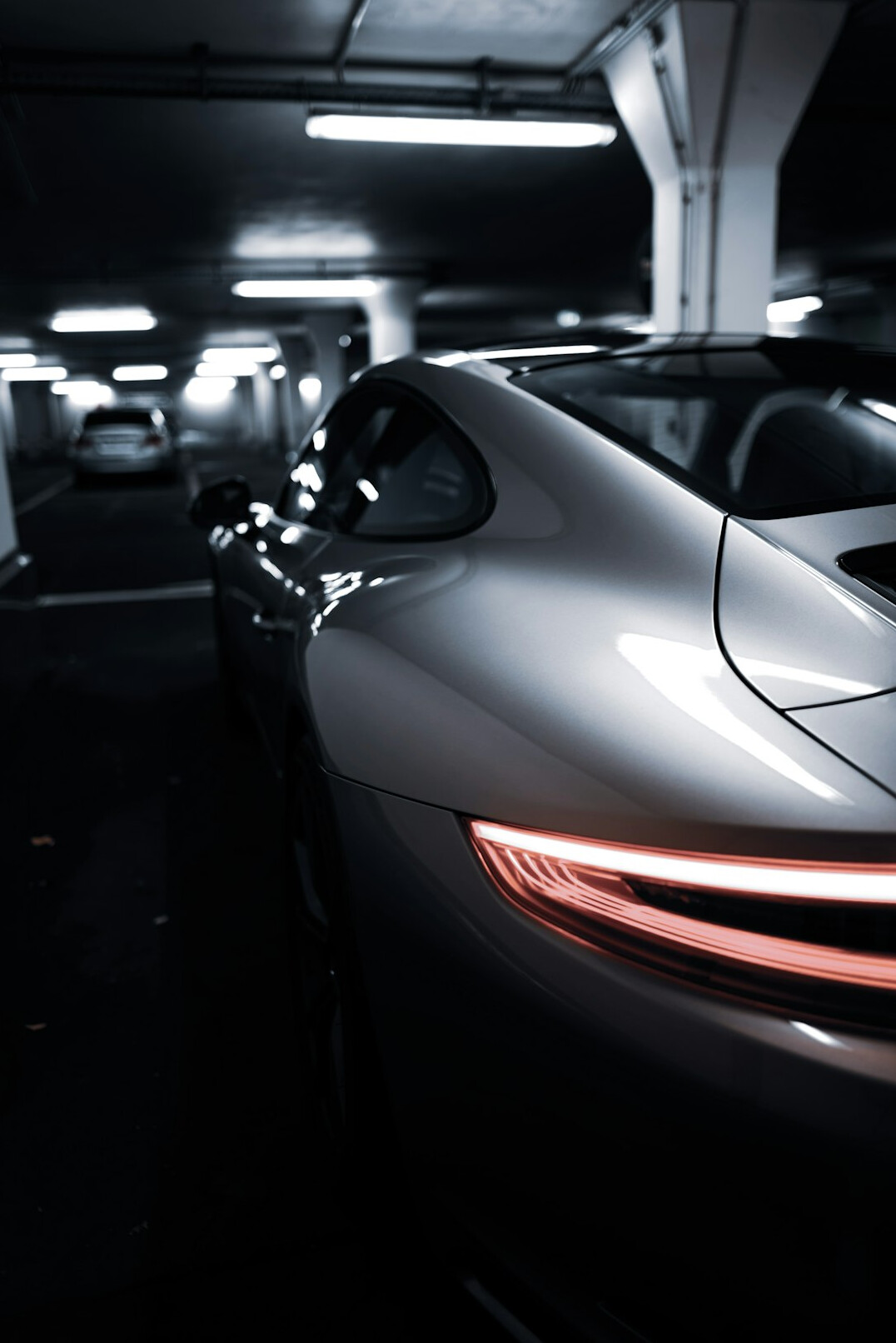 Close-up of a clean car body panel reflecting light in a garage